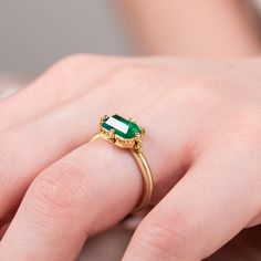 This landscape Emerald ring inspires renewal with its vibrant green hue. We set this one-of-a-kind gemstone in an intricate frame of gold chain and delicate beaded prongs. Ready to ship in size 7. Please allow 1-2 weeks for any other size. Technical Details Metal: 18k yellow goldEmerald: 1.92 cts. Ring face: 6 x 9mmBand width: 2mmHandmade in New YorkStyle # R-2602-EM Faceted Emerald Ring Formal Fine Jewelry, Handmade Oval Emerald Ring Fine Jewelry, Gold Emerald Ring With Intricate Design, Oval Shape, Elegant Multi-stone Emerald Ring In 14k Gold, 14k Gold Green Emerald Ring, Fine Jewelry, Mixed Metal Bracelets, Textile Necklace, Vibrant Green, Bracelet Collection