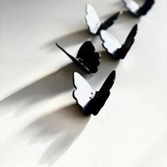 four pieces of black and white paper are arranged in a row on a table top