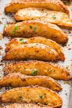 baked chicken wings on a baking sheet with seasoning sprinkles and parsley