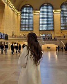 a woman in a white coat is looking at the ceiling