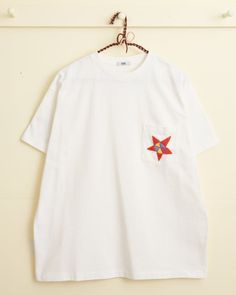 This short-sleeve shirt is inspired by a children's tee from the 1970s. We reproduced the silk-stitched star on the pocket for this style. Boxy fit 100% cotton Made in Portugal Dry clean only View all tees Mens Embroidered T Shirt, Embroider Shirt, Boxy Tshirt, Tshirt Embroidery, Inspirational Shirts, New York Mens, Mens Cuts, Inspirational Shirt, Embroidered Tshirt