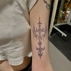 a woman's arm with a cross tattoo on it