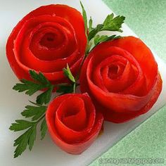 three red roses sitting on top of a white napkin