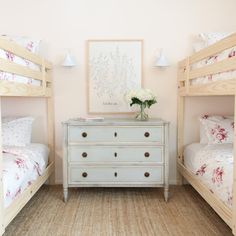 a bedroom with two bunk beds and a dresser