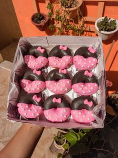 a box filled with lots of pink and black cupcakes