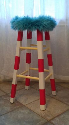 a stool made out of wooden sticks with a blue fur top on it's legs