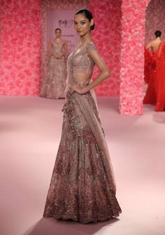 Make a grand entrance in this mauve pink shimmer tulle cocktail lehenga set. The lehenga’s heavy shimmer tulle creates a stunning, opulent effect, while its intricate crystal embellishments ensure a dazzling sparkle. The set includes a dupatta adorned with a 3d floral applique border, adding an elegant and textured touch. Heavily crystallized, this ensemble perfectly blends modern glamour with exquisite craftsmanship, making it an ideal choice for a memorable occasion. Pink Floor-length Evening Lehenga, Floor-length Pink Choli For Evening, Evening Floor-length Pink Lehenga, Pink Floor-length Evening Choli, Pink Anarkali Lehenga For Evening, Pink Organza Lehenga For Evening, Glamorous Pink Dress With Zari Work, Evening Pink Choli With Sheer Dupatta, Pink Evening Choli With Sheer Dupatta