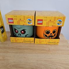 two lego halloween mugs sitting on top of a wooden table