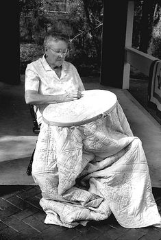 an old man sitting on a bench holding a frisbee