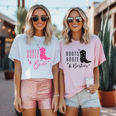 two women standing next to each other wearing pink and white shirts with boots on them