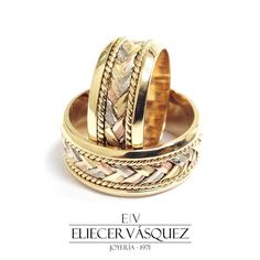 two gold rings with braiding on them are sitting side by side in front of a white background