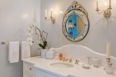 a bathroom with a sink, mirror and candles