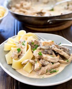 a white plate topped with pasta covered in mushroom sauce and mushrooms on top of it