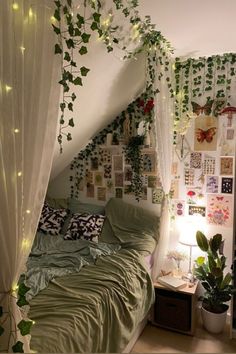 an unmade bed with plants growing on the wall above it and lights hanging from the ceiling