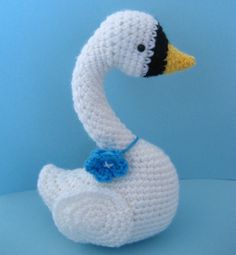 a crocheted white duck sitting on top of a blue surface