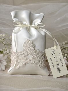 a white bag sitting on top of a table next to some flowers and a tag