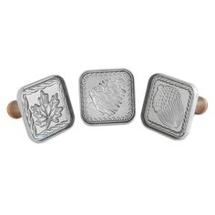 three metal square knobs with decorative designs on the front and back of each one