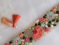 A pretty trim delicately embroidered with little flowers. In pink, peach and teal, on a light beige net. And embellished with small white beads and light gold sequins. Delicate look at, exquisite to use ! Use it to embellish your denim jackets, or border your sarees. Or create home décor like lamps or curtain ties. Or accessories like hair bands. One trim, countless possibilities. Price for 1 mtr Note - Colours may look slightly different to you from what they are, depending on your monitor/ scr Designer Pink Saree With Embroidered Border, Bohemian Wedding Embroidered Fabric With Floral Details, Festive Peach Dupatta With Intricate Embroidery, Pink Traditional Wear With Embroidered Border For Diwali, Diwali Peach Dupatta With Intricate Embroidery, Pink Silk Dupatta With Intricate Embroidery, Traditional Peach Dupatta With Intricate Embroidery, Pink Traditional Wear With Floral Embroidery, Traditional Peach Wear With Floral Embroidery