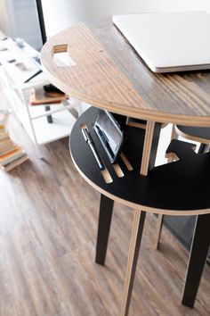 there is a laptop and cell phone on top of the table in this office space