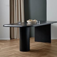 a dining table with a bowl of food on it in front of a curtained window