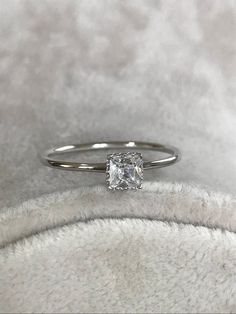 a diamond ring sitting on top of a white blanket