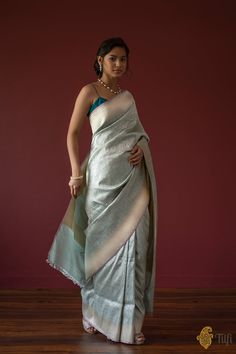 "Handwoven luxury and a rich bed of zari! Inspired by the beauty and geometry of Moroccan artistry, opulent Banarasi craftsmanship and glorious zari come together in this versatile and altogether breathtaking saree.\u00a0\n\u00a0\n\n\n  Color\u00a0-\u00a0A stunning shade of Light Blue\n\n  Technique\u00a0-\u00a0The finest weaving technique passed down through generations of weavers.\u00a0\n\n  Fabric\u00a0- Soft as butter, pure Katan Silk\u00a0\n\n  Speciality\u00a0- This saree features\u00a0beautifully detailed\u00a0geometric weaving\u00a0in silver zari with roopa sona zari borders and pallu. With the right balance of silk, and\u00a0gold and silver zari, this drape strikes the perfect note of elegance.\u00a0\n\n  Tilfi Promise\u00a0- Pure. Handloom. Banaras\nNote - The saree comes with it Twenties Style, Blue Silk Saree, Banaras Sarees, Brocade Saree, Silk Saree Banarasi, Shades Of Light Blue, Blue Saree, Katan Silk, Boutique Dress Designs