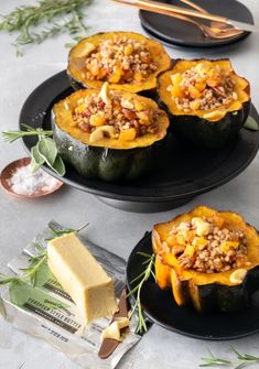 stuffed acorns with meat and vegetables on black plates next to buttered crackers