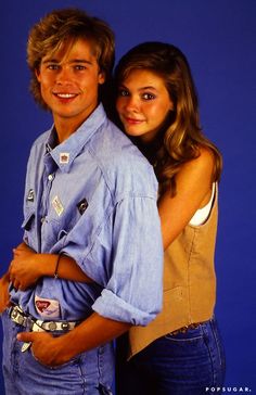 a young man and woman posing for the camera with their arms wrapped around each other