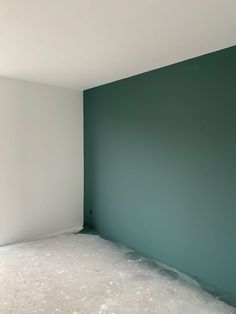 an empty room with green walls and white flooring in the corner is being painted