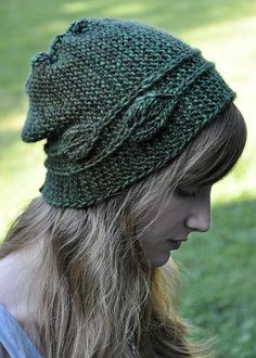 a woman with long hair wearing a green knitted hat