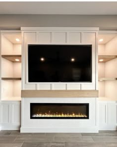 a television mounted above a fireplace in a living room with built - in shelving