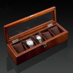 three watches in a wooden box on a black background