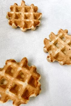 three waffles sitting on top of a white table