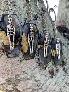 three skeleton key chains hanging from a tree