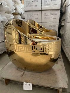 a large metal bowl sitting on top of a wooden table next to stacks of boxes