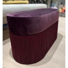 a large purple ottoman sitting on top of a wooden floor