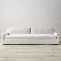 a white couch sitting on top of a hard wood floor