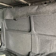 the interior of a vehicle with grey cloth covering it's back and side panels