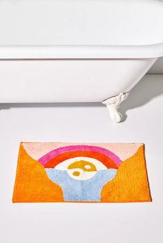 a bathroom rug with an image of a person's face on it in front of a bathtub