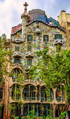 an ornate building with many windows and plants growing on it