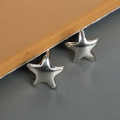 A PAIR of tiny sterling silver star ear studs. Size: 5 x 5 mm. Weight: 0.46gm Price listed is for a PAIR of studs. These earrings are made of 925 hypoallergenic sterling silver Can be packaged in a gift box. I can include a personal message from you if needed You are welcome to contact me at... bhavnakwintra1956@gmail.com For more beautiful pieces from my shop, please browse 👇 TOE RINGS: https://www.etsy.com/your/shops/TheSilverGame/tools/listings/section:27020628,view:table EAR HOOPS: https:// Nickel-free Star-shaped Silver Piercings, Nickel Free Silver Star-shaped Piercing, Nickel-free Silver Star Piercings, Minimalist Silver Star Piercings, Sterling Silver Star-shaped Piercings, Silver Star-shaped Sterling Silver Piercings, Sterling Silver Star Piercings In Silver, Nickel-free Star-shaped Cartilage Earrings As Gift, Nickel-free Star-shaped Cartilage Earrings For Gifts