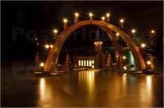 an arch with candles lit up in the night