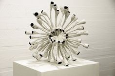 a white sculpture with black dots on it