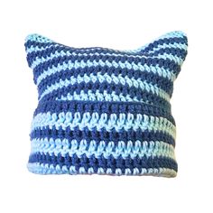 a blue and white crocheted pillow on a white background