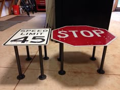 two street signs sitting next to each other on top of a tile floor in a garage