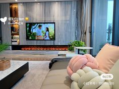 a living room with couches and a flat screen tv on the wall in front of it