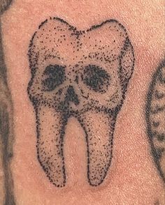 a close up of a person's arm with a tattoo on it that looks like a tooth