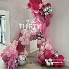 pink and silver balloons are on display in front of a mirror that says talk thirty