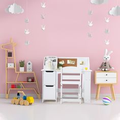 a child's room with pink walls and white furniture