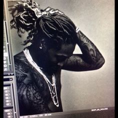 a black and white photo of a man with dreadlocks on his head in front of a computer screen